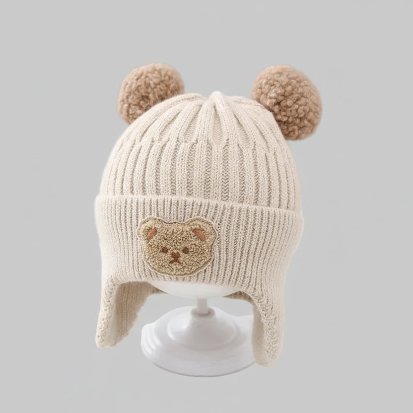 Baby wintermuts beige beer pompons oorflappen op standaard vooraanzicht