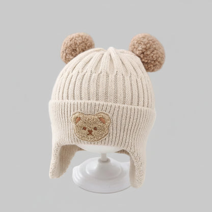 Baby wintermuts beige beer pompons oorflappen op standaard vooraanzicht