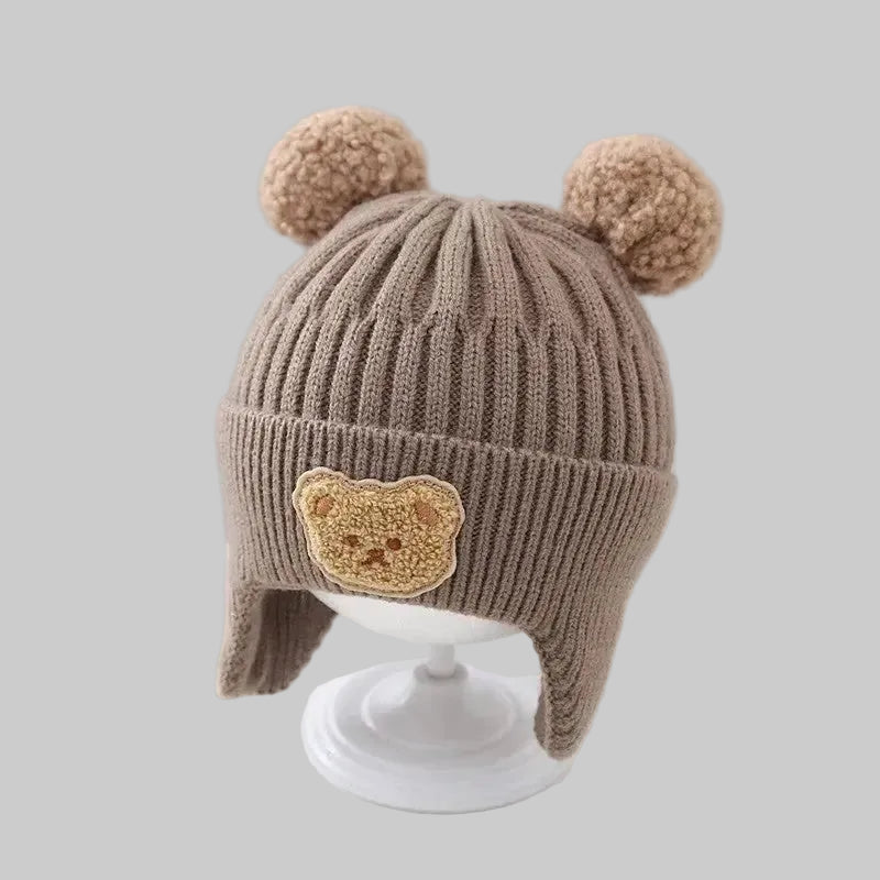 Baby wintermuts koffie beer pompons oorflappen vooraanzicht