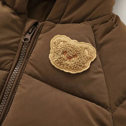 Teddy beer badge op bruine gewatteerde winterjas close-up detail